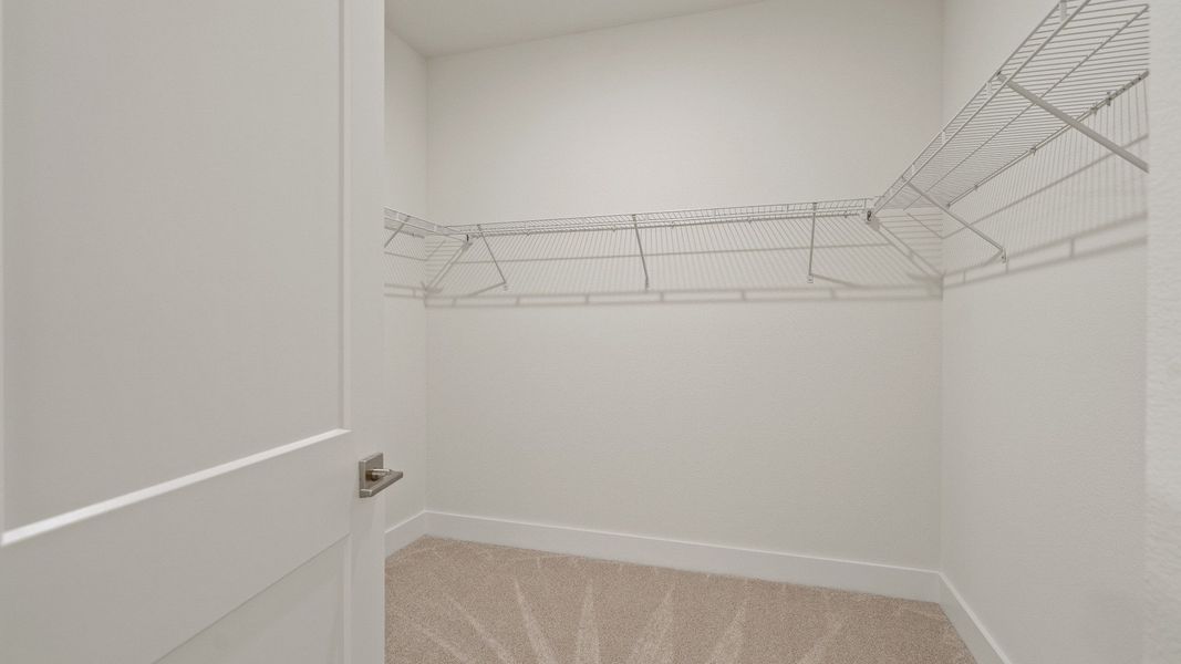 Primary walk-in closet in the Buttonwood floorplan by DRB Homes at Lakeside at Satilla in Saint Cloud, FL