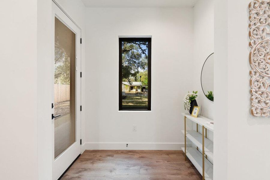 Doorway to outside with wood finished floors and baseboards