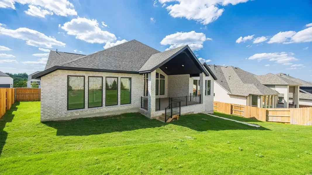 Back of house with a patio area, a fenced backyard, a shingled roof, and brick siding Back of house with a patio area, a fenced backyard, a shingled roof, and brick siding