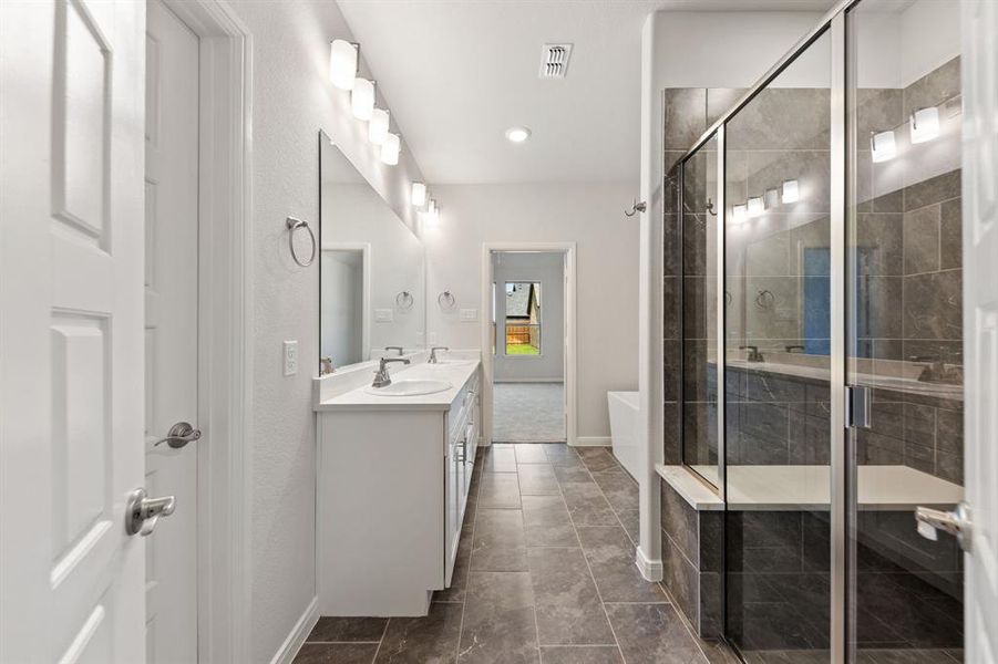 You'll find a spacious walk in shower and relaxing free standing tub in this owner's bath.