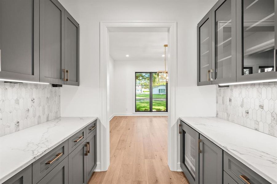 Bar area featuring backsplash, gray cabinetry, light stone counters, light wood finished floors, and recessed lighting Bar area featuring backsplash, gray cabinetry, light stone counters, light wood finished floors, and recessed lighting