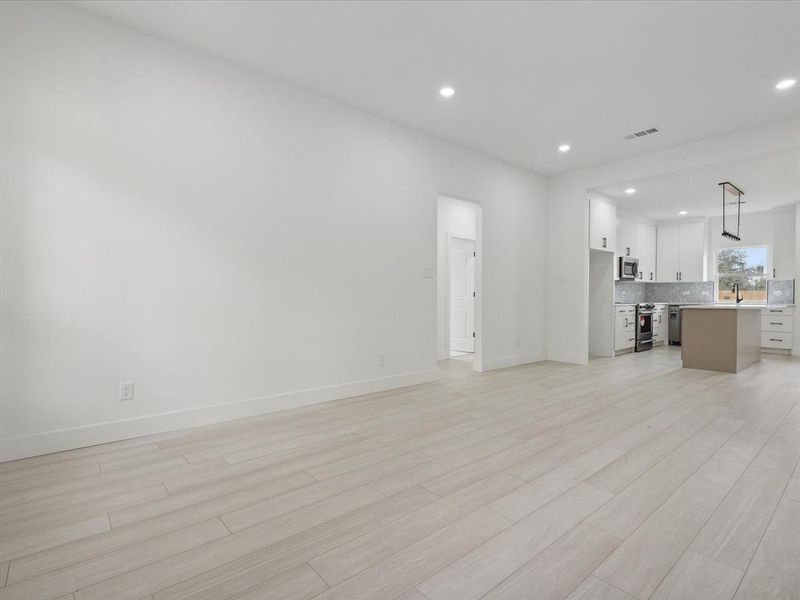 Unfurnished living room with light wood-type flooring and sink