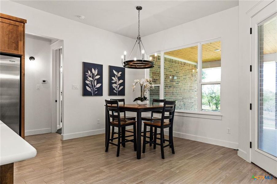 Dining area featuring light wood finished floors and a chandelier