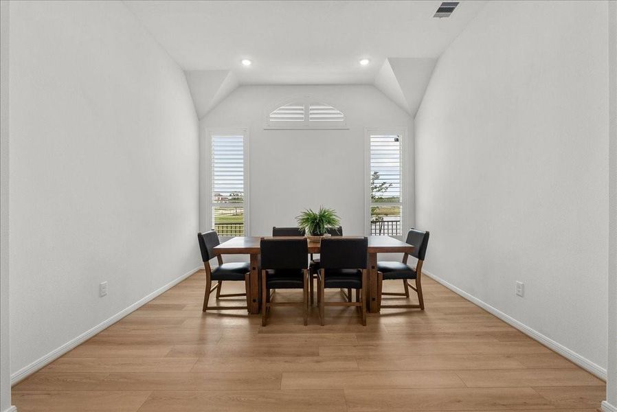 Formal dining room with serene water views, creating the perfect setting for entertaining and gatherings.