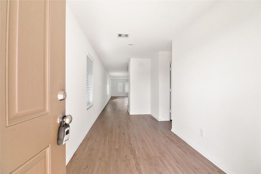 Bright entry hallway with durable wood-style flooring and an open sightline that draws you into the home Bright entry hallway with durable wood-style flooring and an open sightline that draws you into the home