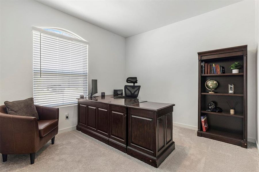 Staged as an office - Arched window with blinds, light gray wall paint, and light gray carpeted flooring Staged as an office - Arched window with blinds, light gray wall paint, and light gray carpeted flooring