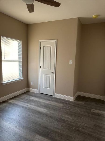 Spare room featuring a ceiling fan, dark wood-type flooring, baseboards, and a smoke detector