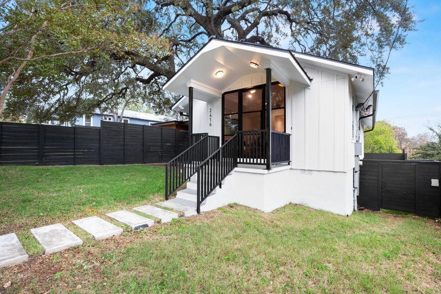 View of front of property with board and batten siding and a gate