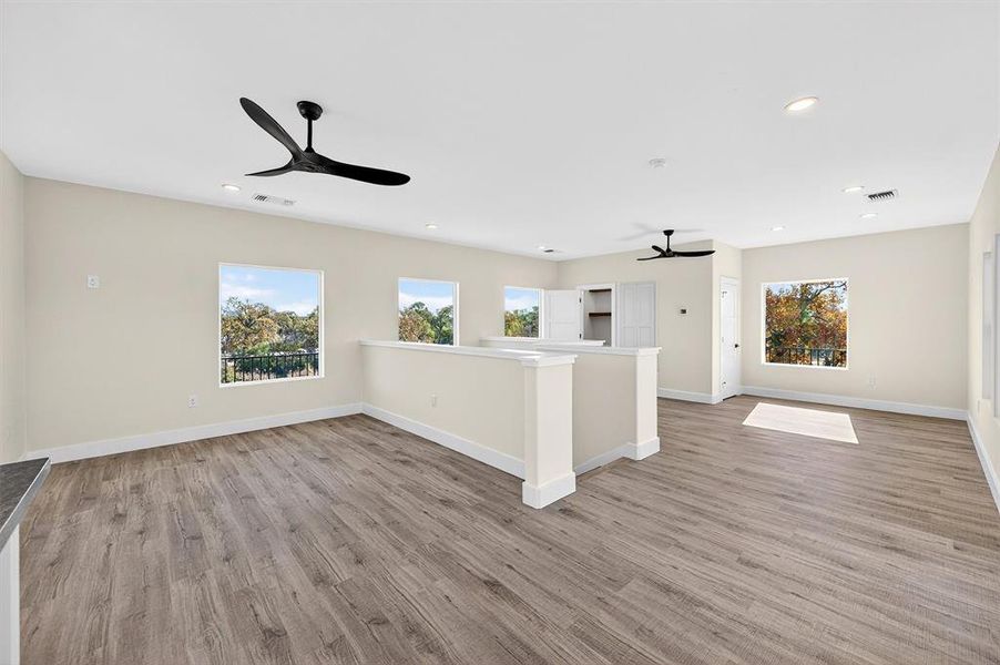 Unfurnished living room featuring light wood finished floors, plenty of natural light, recessed lighting, and ceiling fan
