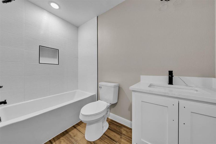 Bathroom with vanity, wood finished floors, shower / bath combination, and recessed lighting Bathroom with vanity, wood finished floors, shower / bath combination, and recessed lighting