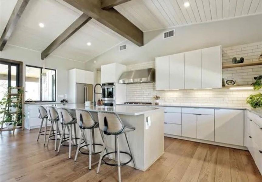 Kitchen with white cabinets, a large island with sink, modern cabinets, a breakfast bar area, and decorative backsplash Kitchen with white cabinets, a large island with sink, modern cabinets, a breakfast bar area, and decorative backsplash