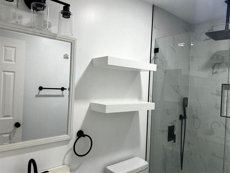 Bathroom featuring an enclosed shower and toilet