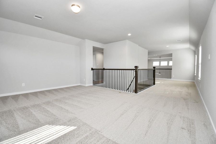 Come upstairs and relish a day of relaxation in this loft area! Ideal as an additional living space or game room, it boasts plush carpeting, high ceilings, custom paint, and windows that flood the area with abundant natural light. Sample photo of completed home with similar floor plan. Actual colors and selections may vary. Come upstairs and relish a day of relaxation in this loft area! Ideal as an additional living space or game room, it boasts plush carpeting, high ceilings, custom paint, and windows that flood the area with abundant natural light. Sample photo of completed home with similar floor plan. Actual colors and selections may vary.