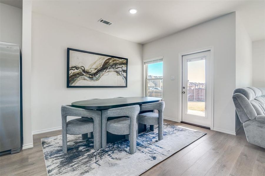 Dining area with light wood-style floors and recessed lighting Dining area with light wood-style floors and recessed lighting