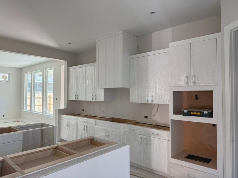 Kitchen with white cabinetry and black electric cooktop