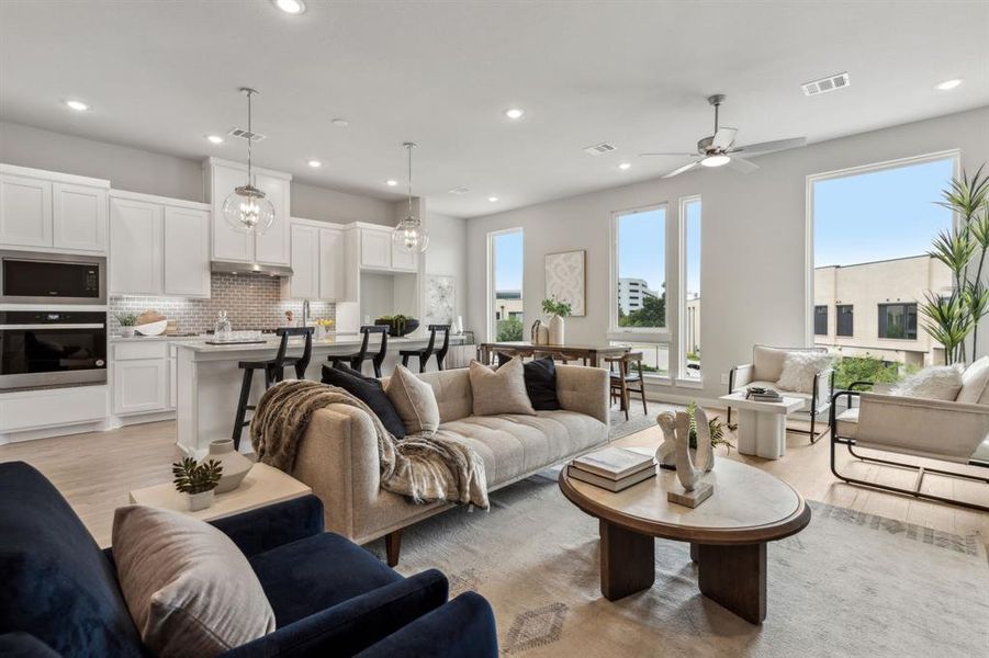 Living room featuring ceiling fan and light hardwood / wood-style flooring