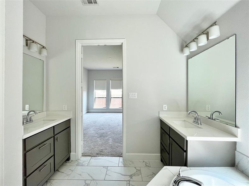 Full bath with light marble finish floors and two vanities Full bath with light marble finish floors and two vanities