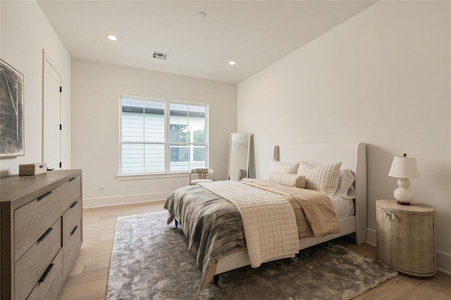 A spacious secondary bedroom offers generous proportions and excellent natural light, with ample room for a king-size bed and additional seating.