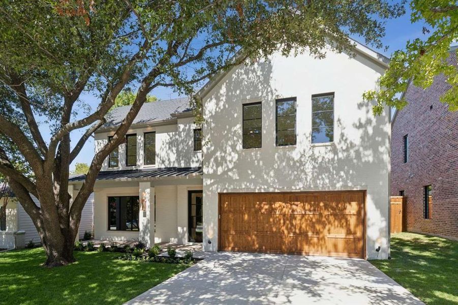 View of front facade featuring a front yard and a garage