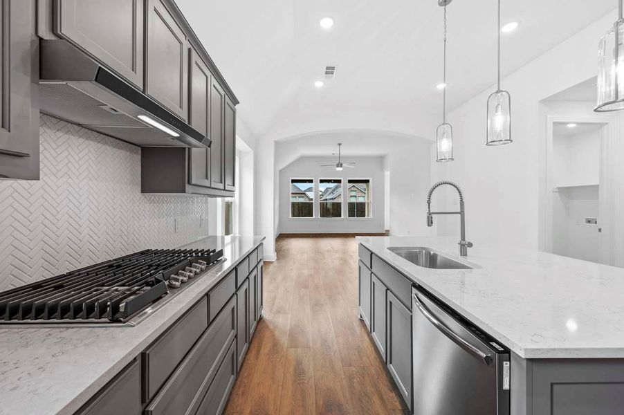 Kitchen featuring a sink, stainless steel appliances, under cabinet range hood, ceiling fan, and decorative backsplash