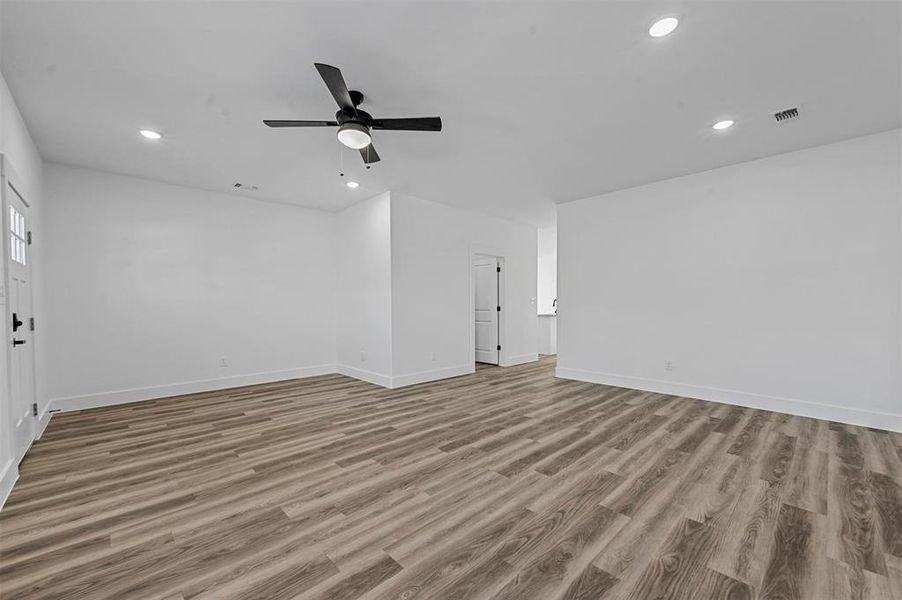 Unfurnished living room with light wood-type flooring and ceiling fan