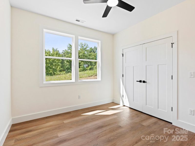 Guest bedroom 2 is located in the center of the hall across from the laundry room.