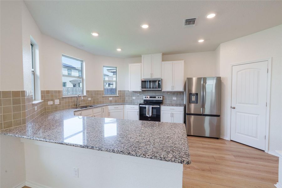 A well-lit kitchen boasts granite countertops and stainless steel appliances, perfect for entertaining. A well-lit kitchen boasts granite countertops and stainless steel appliances, perfect for entertaining.
