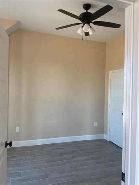 Unfurnished room featuring wood finish floors and a ceiling fan Unfurnished room featuring wood finish floors and a ceiling fan