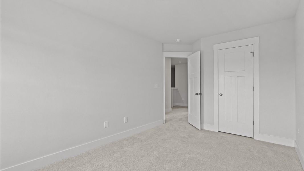 Notable secondary bedroom offering cozy carpeted flooring and a stylish walk-in closet