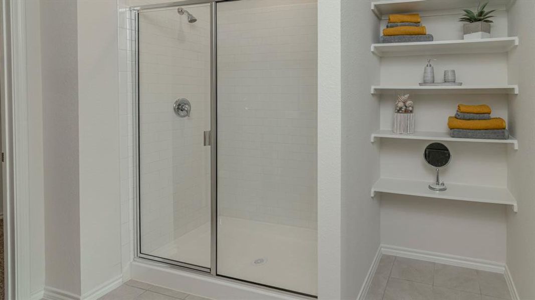 Shower enclosure with clear glass door and a tiled interior