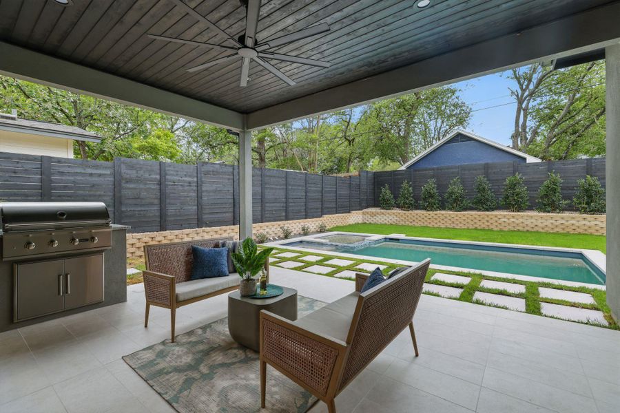 Fenced backyard featuring area for grilling, a patio, ceiling fan, and a pool with connected hot tub