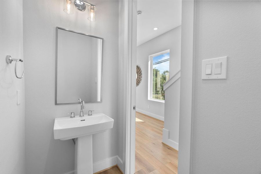 Stylish powder room featuring a pedestal sink and modern lighting, perfectly positioned for guests on the 2nd floor