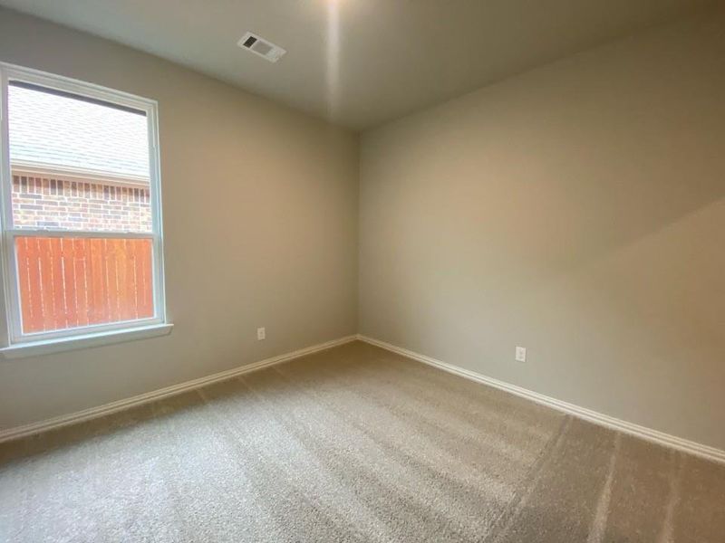 Carpeted room with neutral wall tones and a window featuring white trim Carpeted room with neutral wall tones and a window featuring white trim