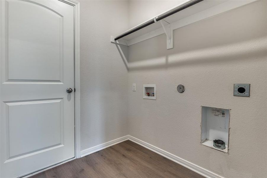 Laundry area with hookup for a gas dryer, hookup for an electric dryer, hookup for a washing machine, and dark wood-type flooring