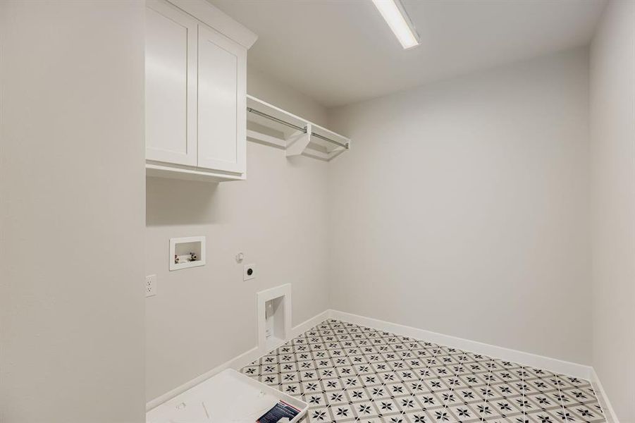 Washroom with cabinet space, hookup for a gas dryer, hookup for an electric dryer, hookup for a washing machine, and light floors