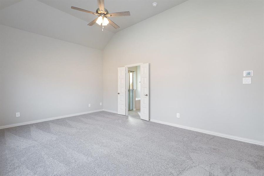 Empty room with ceiling fan and high vaulted ceiling