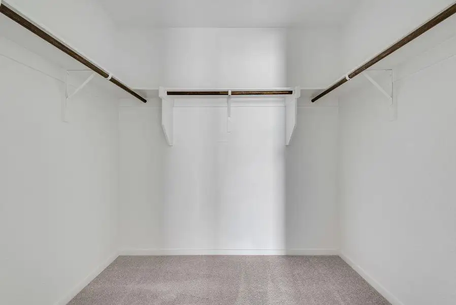 Walk in closet featuring light carpet Walk in closet featuring light carpet