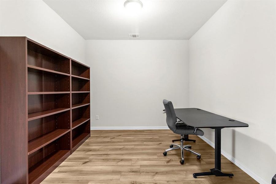 Unfurnished office with wood finished floors and baseboards Unfurnished office with wood finished floors and baseboards
