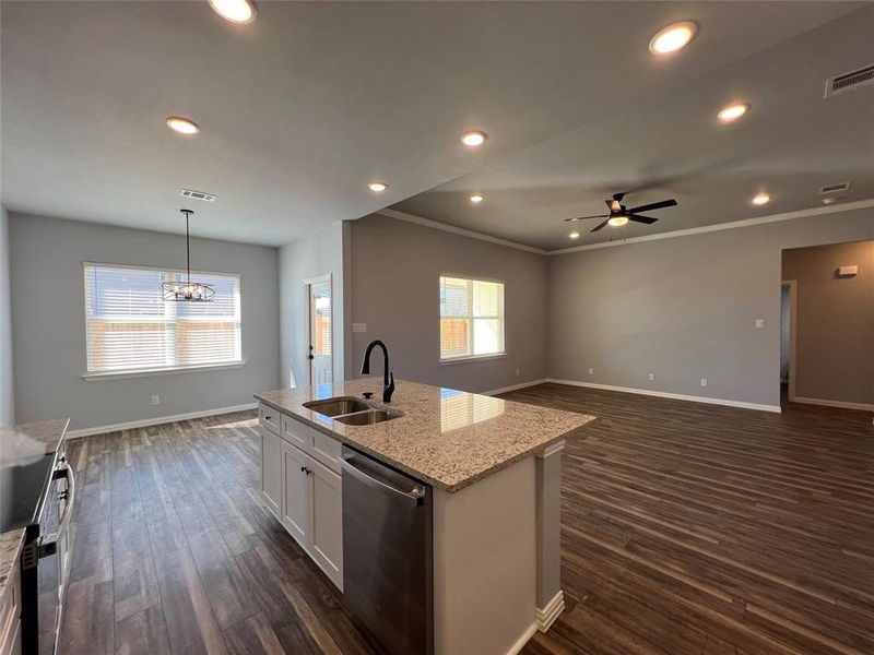 Kitchen with stainless steel dishwasher, a kitchen island with sink, sink, dark hardwood / wood-style floors, and white cabinetry