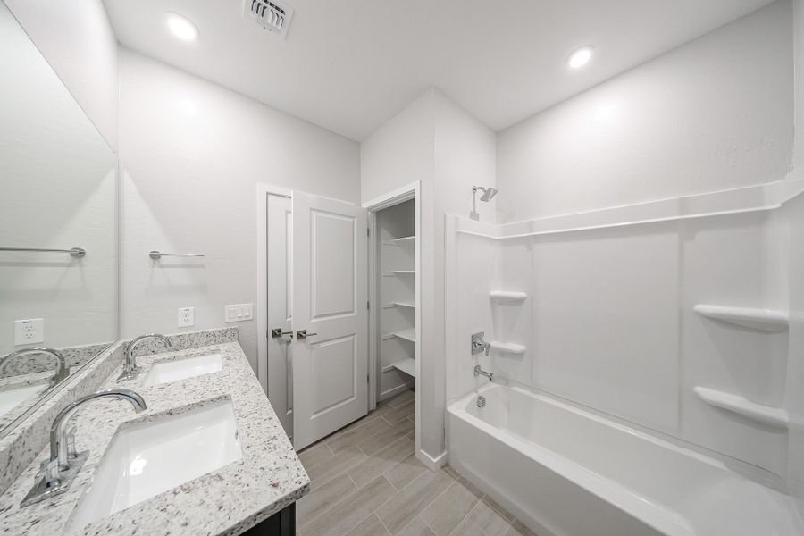A bathroom with a tub sink and a bathtub.
