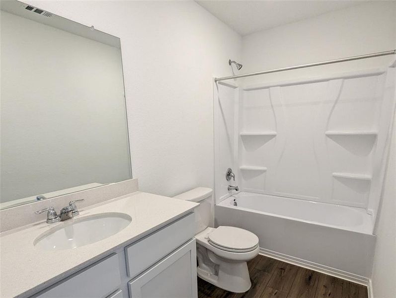 A well-appointed bathroom features a classic shower-tub combination and a clean, functional vanity.