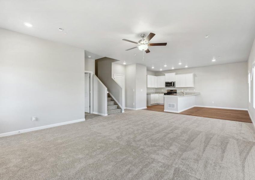 The family room is spacious and has ceiling fan.