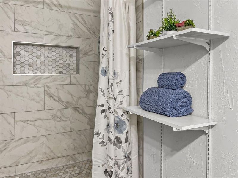 Bathroom featuring a tiled walk-in shower with curtain