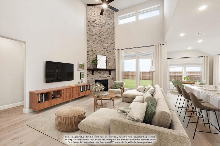 Open living room with two-story stone fireplace, sectional sofa, and hardwood floors