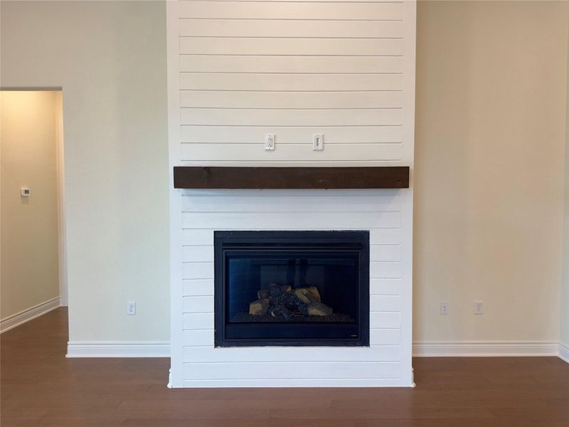 Detailed view of a fireplace and wood finished floors