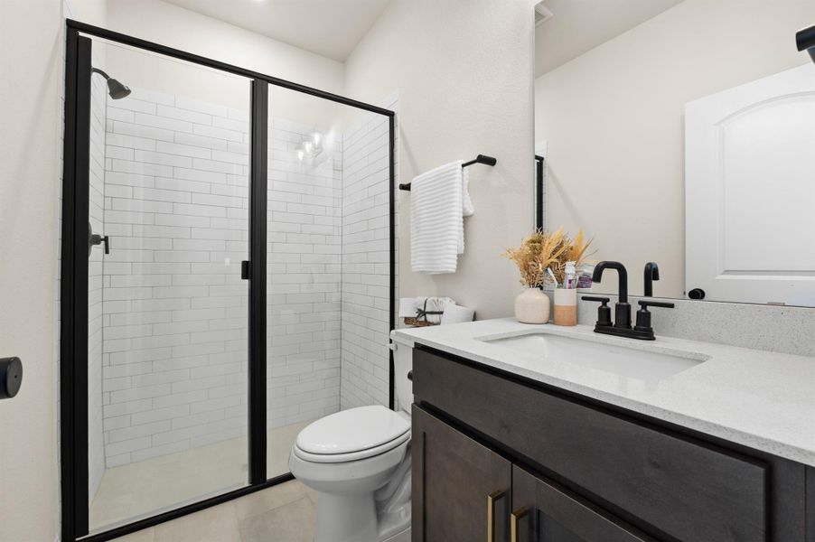 Full bathroom with vanity, a stall shower, and light tile patterned floors Full bathroom with vanity, a stall shower, and light tile patterned floors