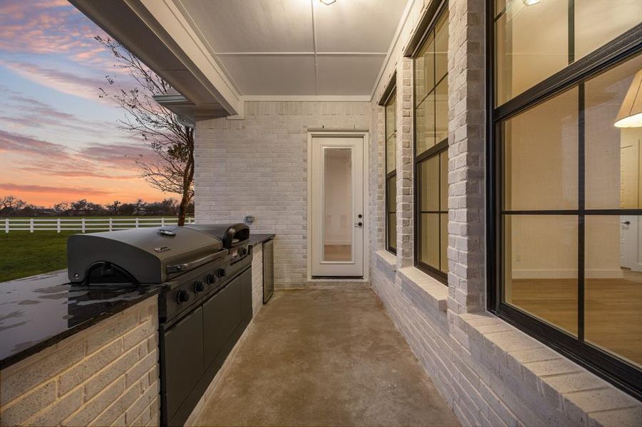 Patio terrace at dusk with a patio area and area for grilling