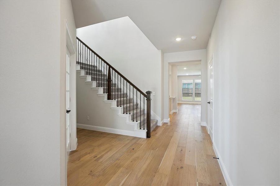 Stairway featuring hardwood / wood-style floors, recessed lighting, and baseboards