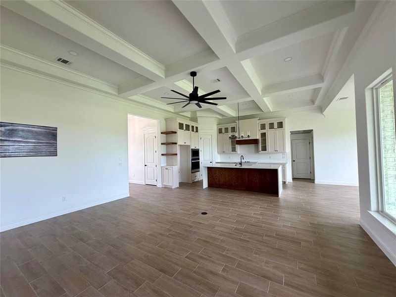 Open-concept living space with coffered ceilings and recessed lighting