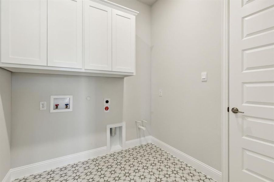 Washroom featuring hookup for an electric dryer, gas dryer hookup, cabinets, and washer hookup